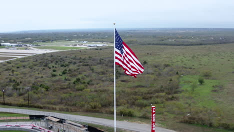 Drone-Nublado-Durante-El-Día-Volando-Alrededor-De-La-Bandera-De-Estados-Unidos-En-El-Viento