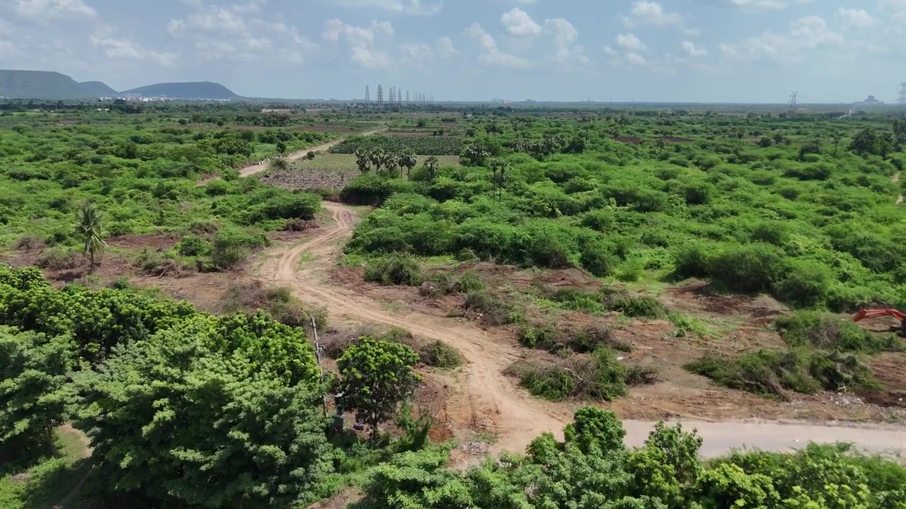 Ampia vista con drone di un lungo tratto di strada che attraversa un paesaggio verde ad Amaravati, Vijayawada.