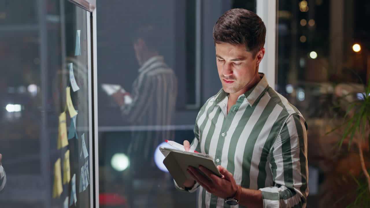 Man working on tablet at night in office