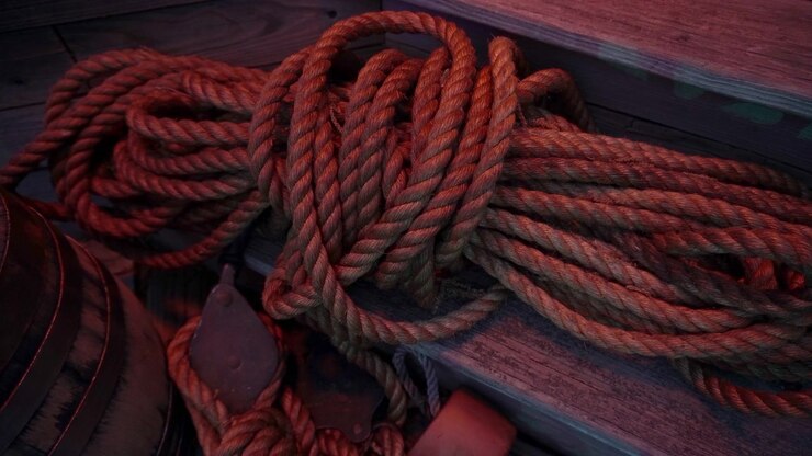 Coiled hemp rope lays on ship's deck.