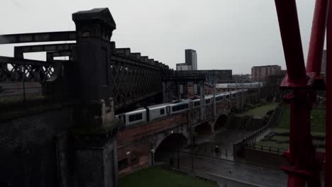 train rolling along track on bridge passing out of sight