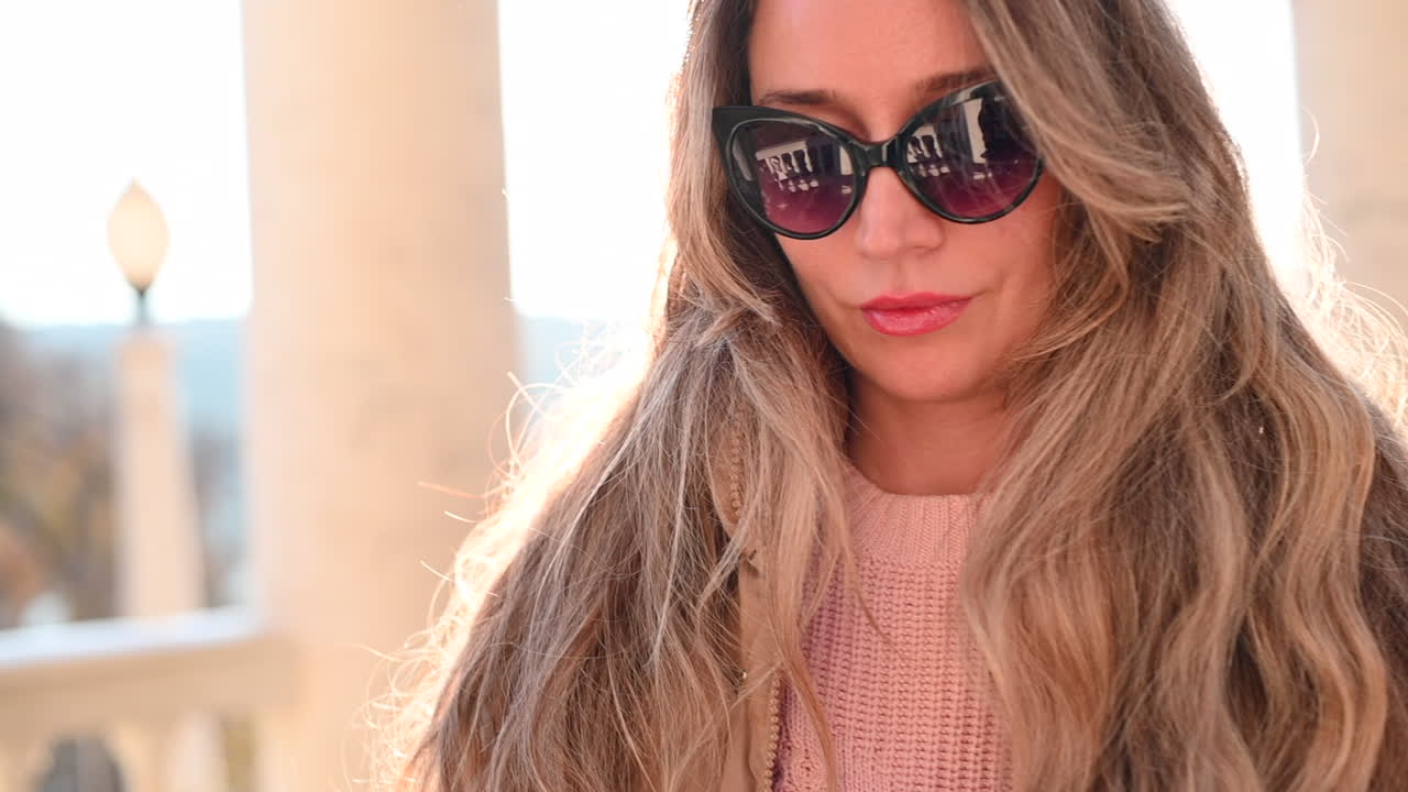Woman wearing black glasses at sunset in a park