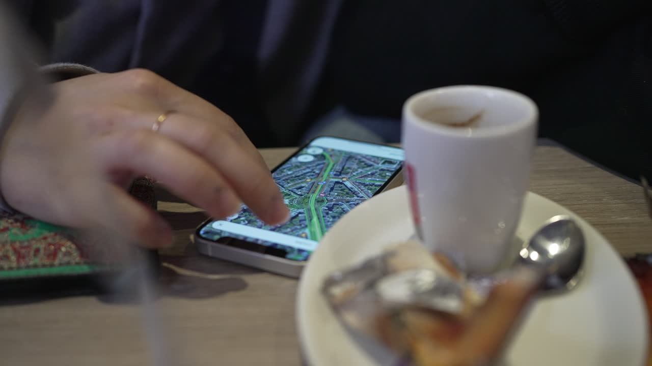 detalle de primer plano de una mujer que usa mapas de google por teléfono en un café