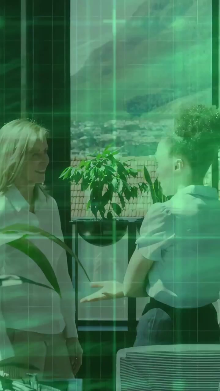 Video verticale: Due donne iniziano a chiacchierare vicino a una finestra, indicando una pianta mentre un HUD mostra la planimetria dell'ufficio.