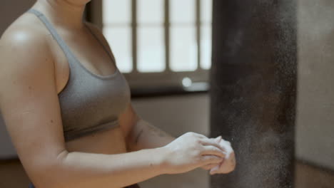 medium shot of athlete clapping hands with chalk powder in it