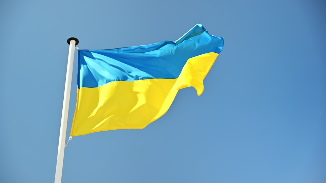La bandiera ucraina sventola al vento sul pennone. Cielo blu sullo sfondo. Rallentatore