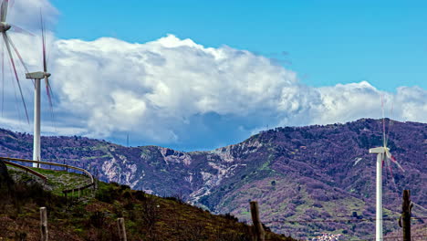 lapso de tiempo de la granja de turbinas eólicas giratorias en colinas y nubes que pasan rápidamente