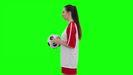 video of caucasian female football player holding football and copy space on green screen