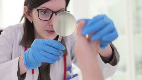 Doctor examining foot with magnifying glass
