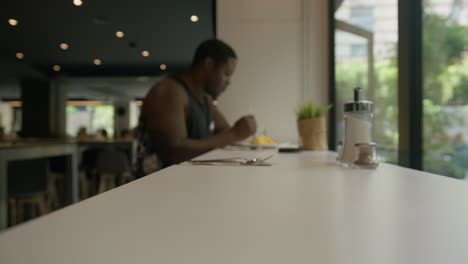 Blurry-Black-Male-Eating-Breakfast-In-Hotel,-Getting-Up-and-Leaving-in-Barcelona,-Spain-in-6K