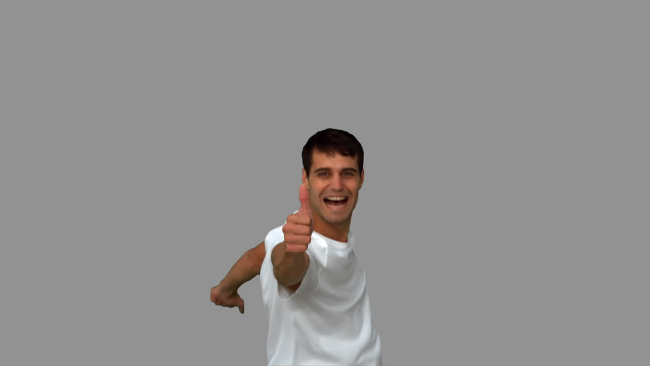 hombre guapo dando pulgares en la pantalla gris