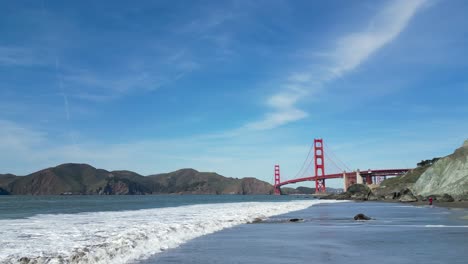 Hombre-Caminando-Por-La-Playa-Hacia-El-Puente-Golden-Gate-En-San-Francisco,-California