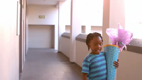 Cute-schoolboy-with-gift-running-in-corridor