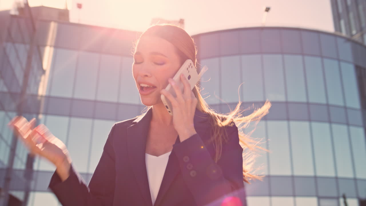 행복 한 사업가 여자 는 사무실 근처 의 니 스트리트 에서 휴대 전화 를 즐기고 있다