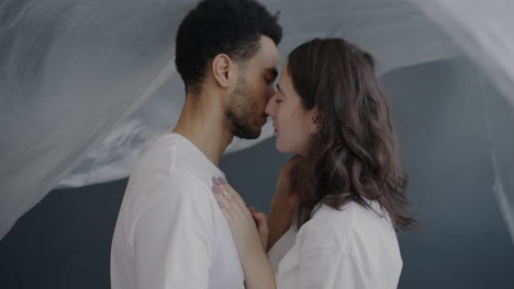 couple kissing under a sheer fabric