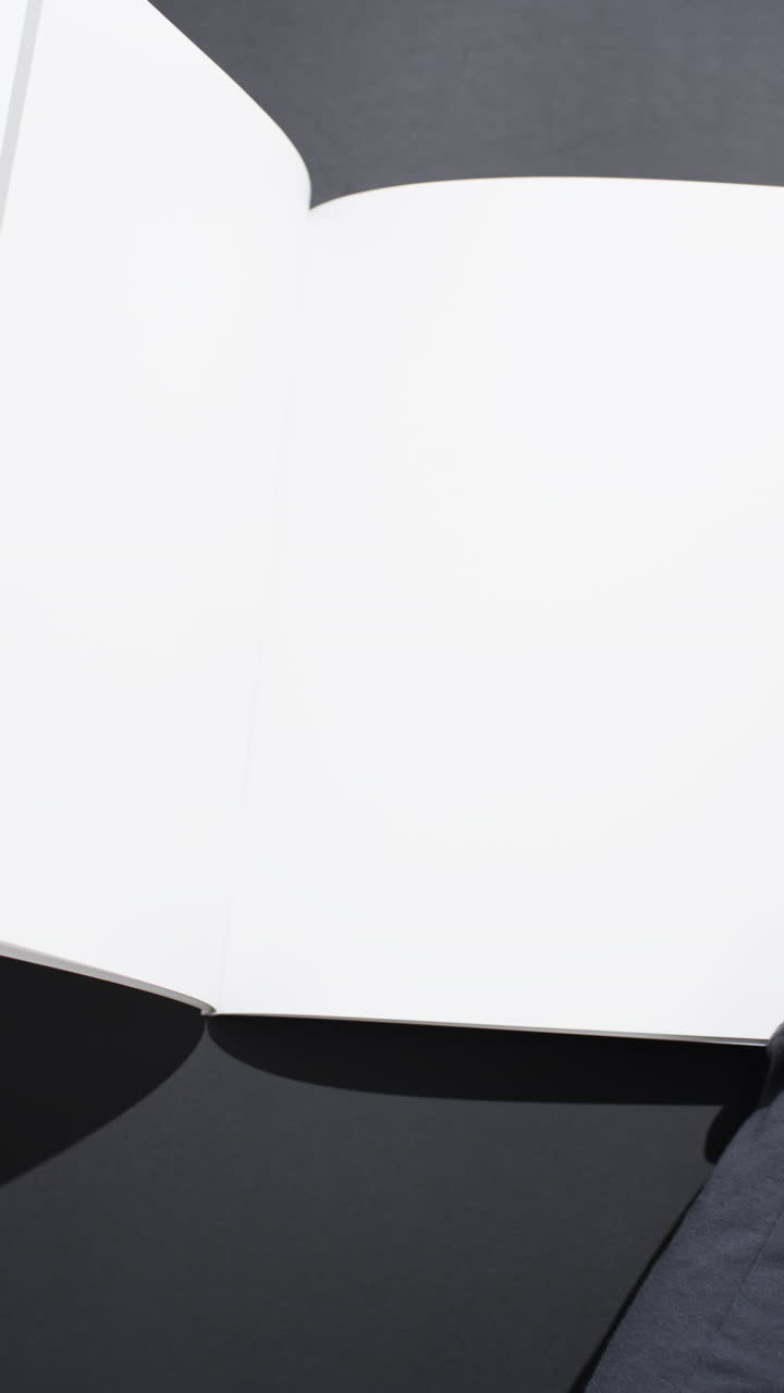 Vertical video of book with white blank pages and copy space on black background