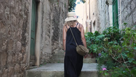 Female-Tourists-Walking-Up-The-Stairs-Between-Old-Buildings-In-Town