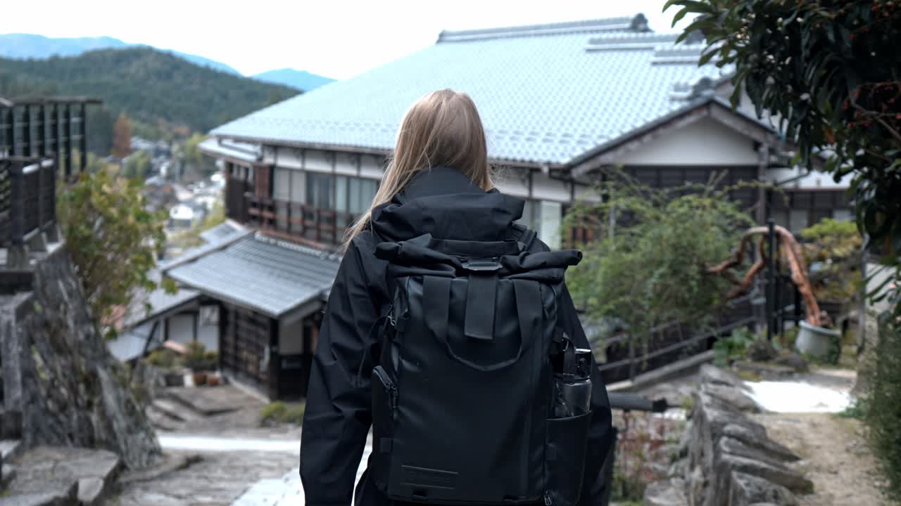 A serene stock video of a girl walking through the picturesque village of Magome, part of the historic Nakasendo Trail in Japan.