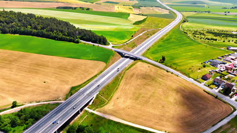 modern highways cross the fields with forests and rural area. drone footage above countryside of slovakia on sunny day