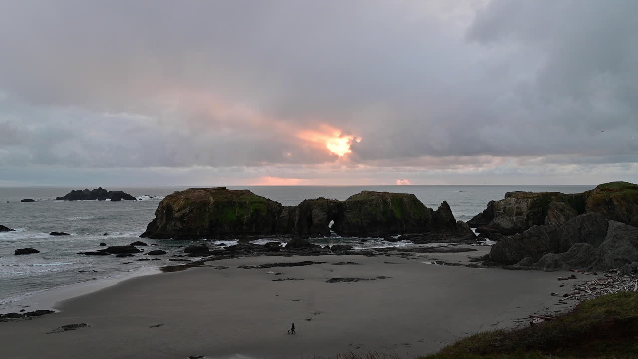 vista de la formación de roca elefante con rayos de sol a través de las nubes en el cielo en bandon, costa de oregon - tiro estático