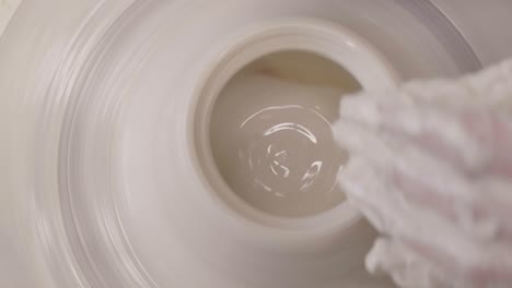 potter working on potter wheel in ceramic workshop
