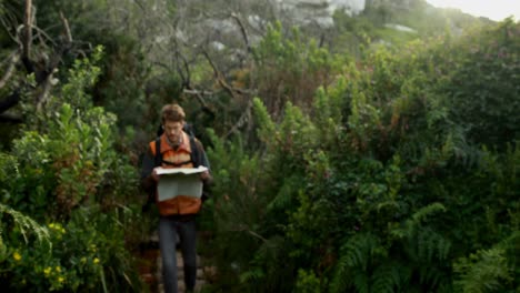 male hiker walking with map in countryside 4k