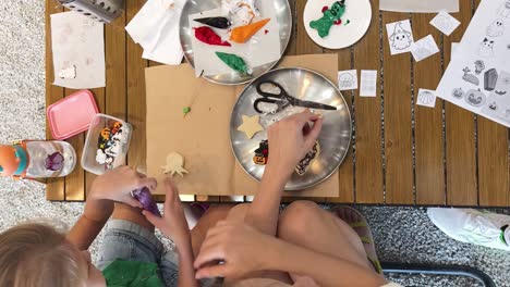 mom and daughter decorating halloween cookies