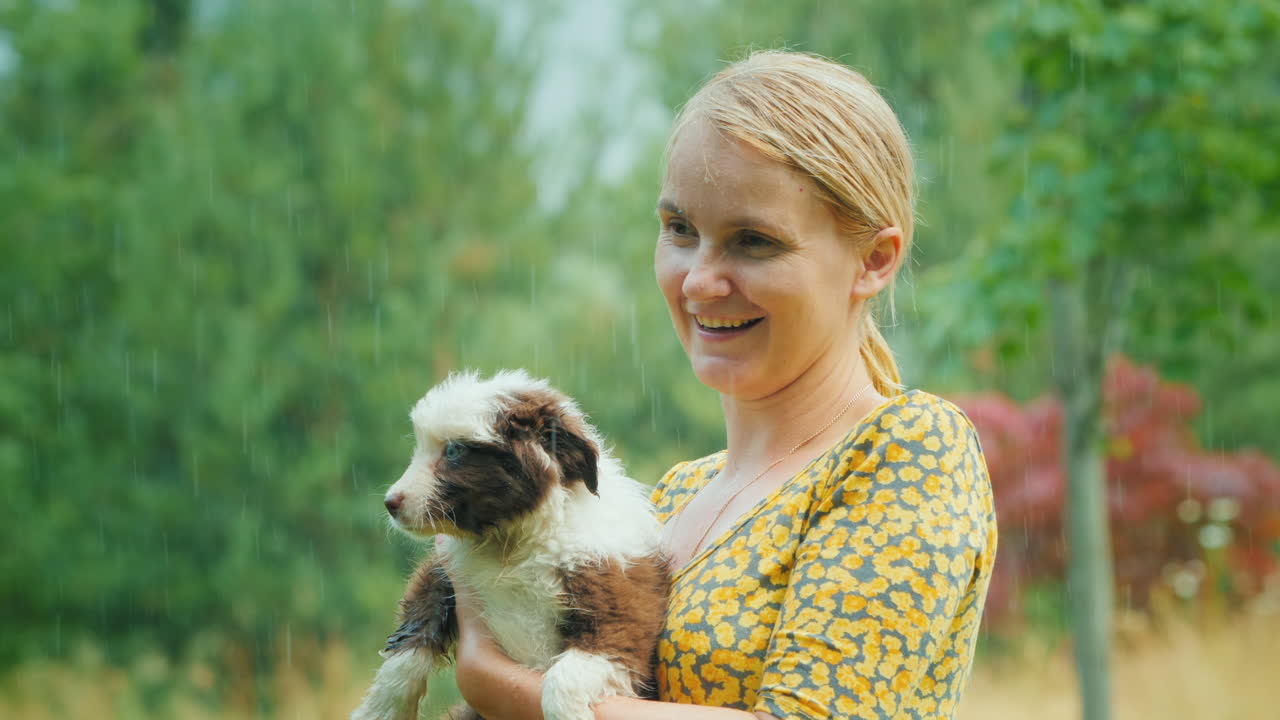 쏟아지는 여름비 속에서 강아지를 품에 안고 있는 감성적인 여성, 잊을 수 없는 삶의 순간들