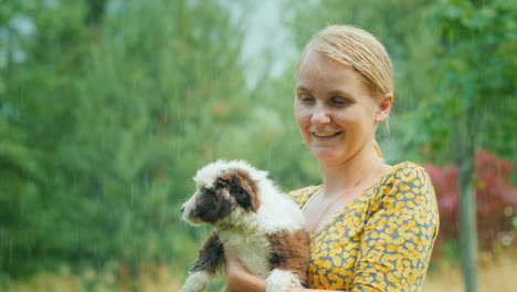 Mujer-Emocional-Con-Un-Cachorro-En-Sus-Brazos-En-La-Lluvia-Torrencial-De-Verano-Momentos-Inolvidables-De-La-Vida