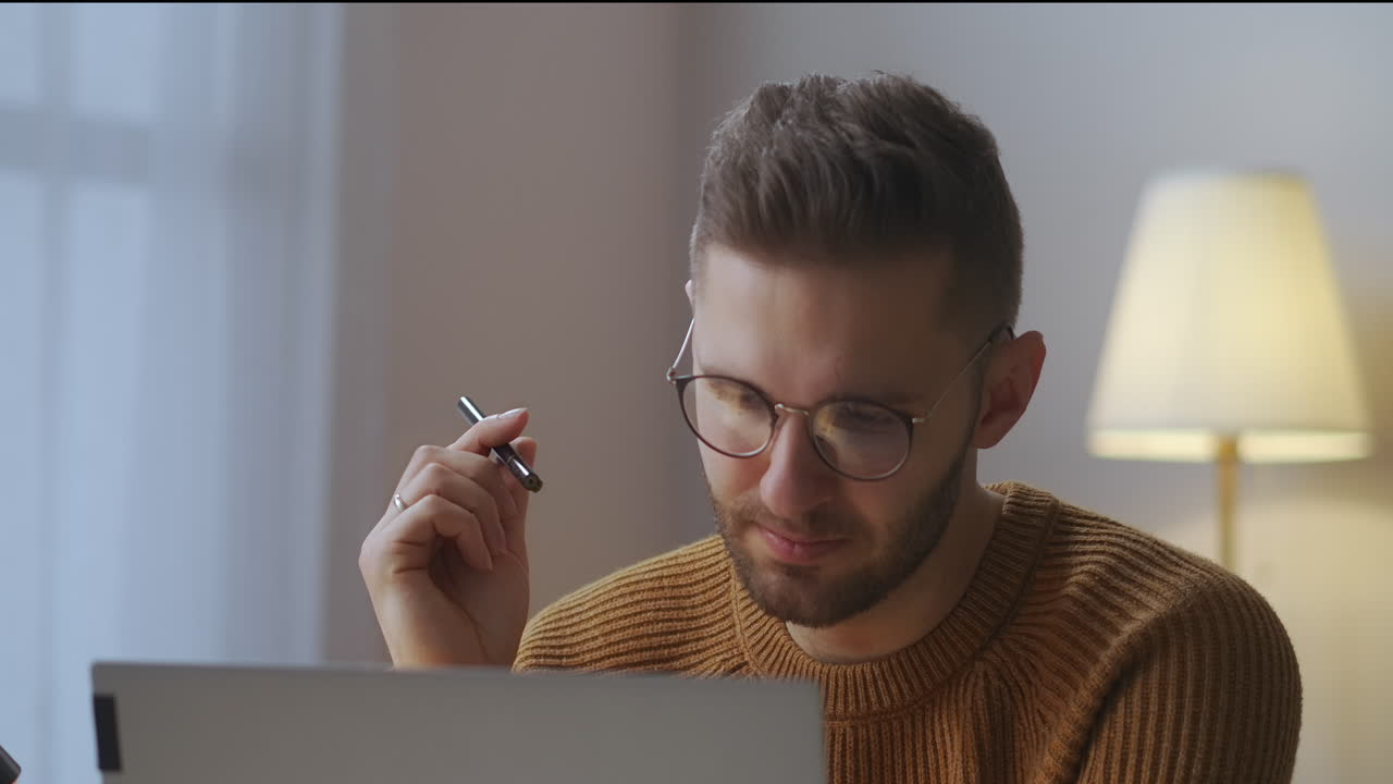 estudiante masculino adulto está escuchando un webinar en línea o una conferencia en la exhibición de una computadora portátil en casa retrato de aprendizaje electrónico de un joven con gafas
