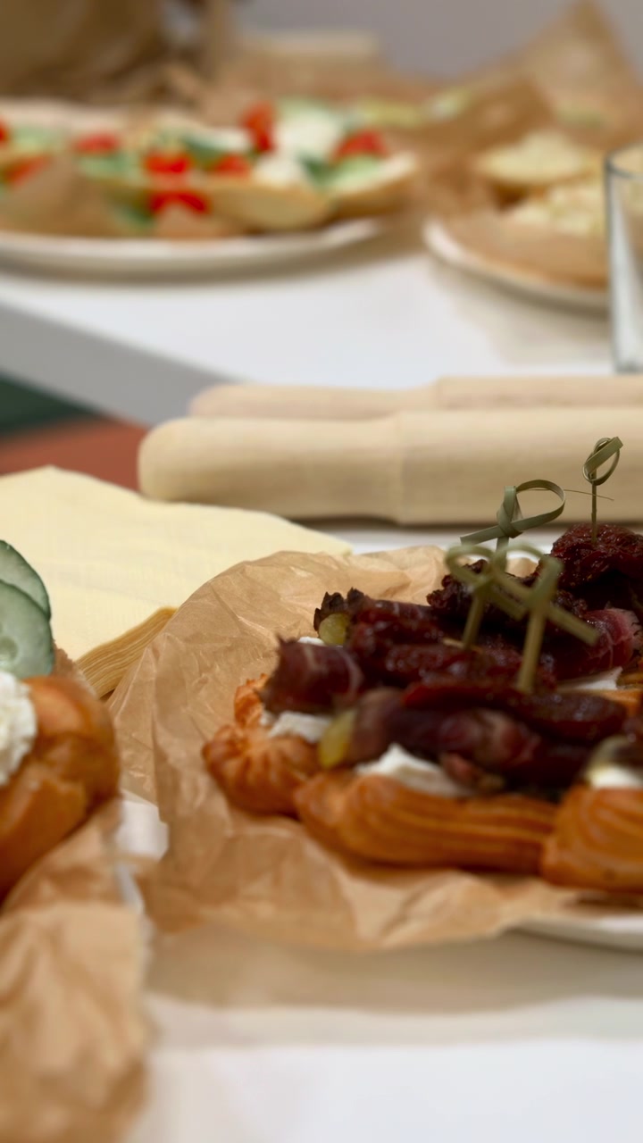 Piatto di bruschette ai gamberi: crostini avvolti in carta forno e guarniti con gamberi e crema alle erbe.