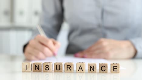 insurance agent writes statement on table by hand