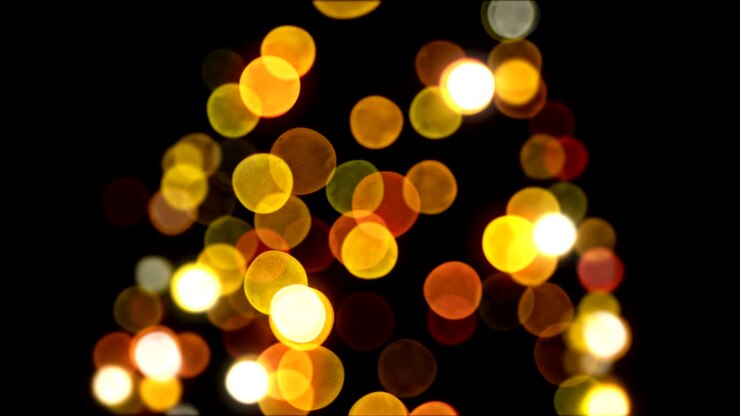 Luci bokeh dell'albero di Capodanno che lampeggiano senza soluzione di continuità su sfondo nero. Animazione 3D in loop. Concetto di Buon Natale e Felice Anno Nuovo