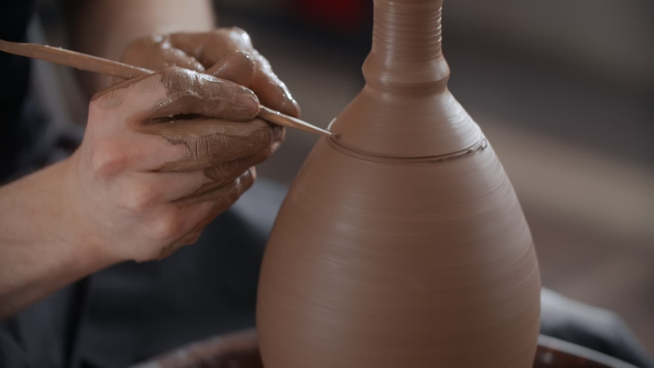 Artisan Potter Shaping Clay Vessel on Wheel