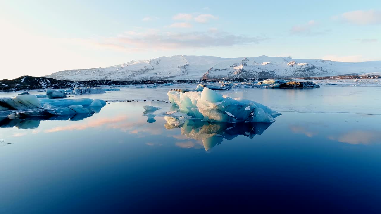 아이슬란드의 하 빙산 위에서 푸른 바다에서 볼 수 있는 해파리의 모습 - 해가 지는 배경에는 빙하가 있습니다.
