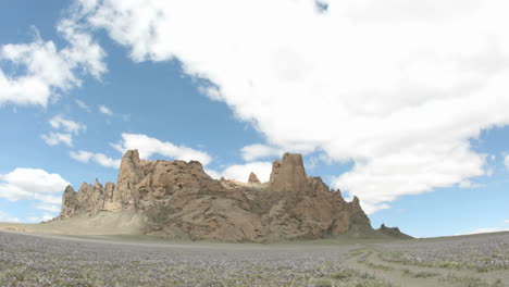 Sunlight-reflects-in-patches-as-fluffy-white-clouds-pass-over-New-Mexico\'s-Shiprock