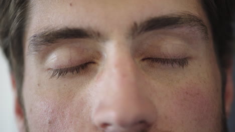 close up attractive young man eyes opening awake looking at camera