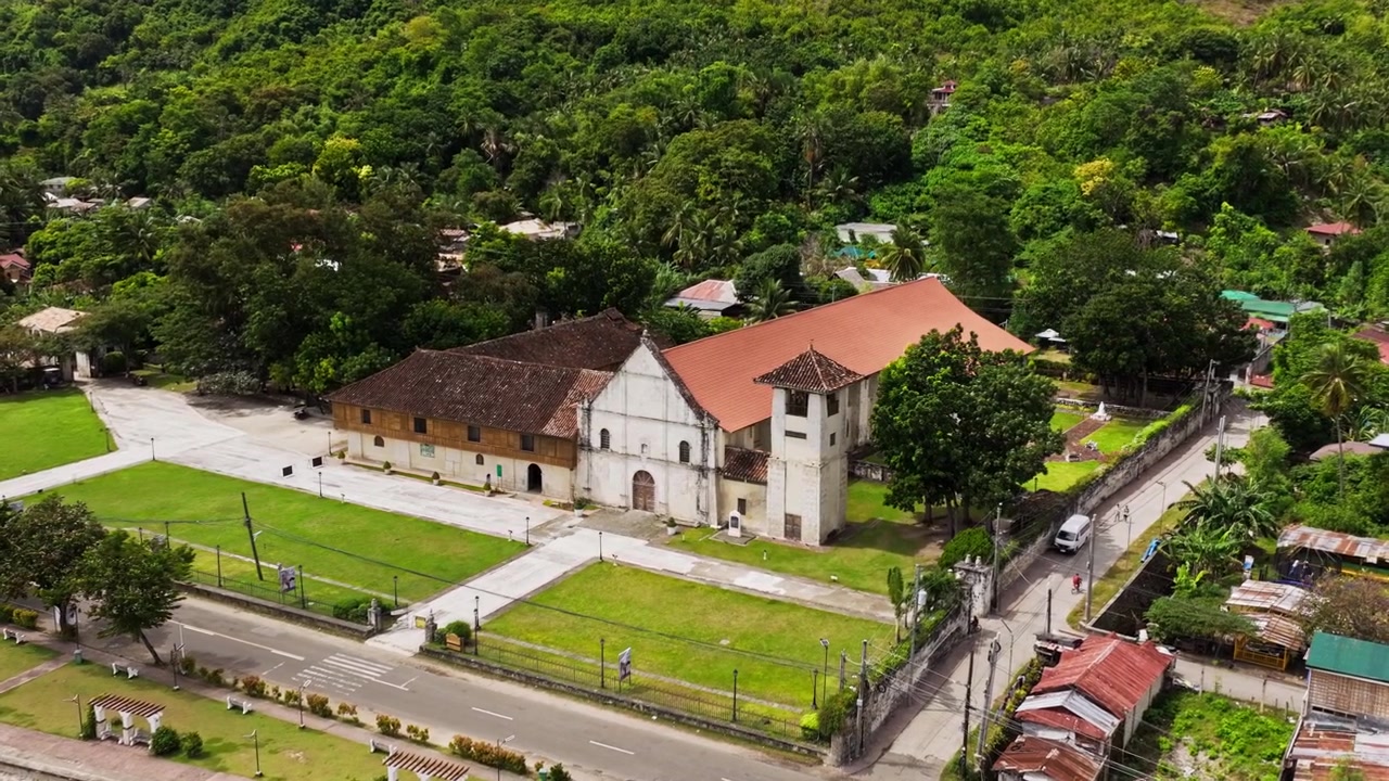 Drone si muove a destra avvicinandosi alla Chiesa di Boljoon, Cebu, Filippine, un monumento storico.