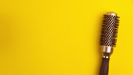 plantilla de animación stop motion capa plana de oro cepillo de cabello redondo para el estilo que se balancea hacia adelante y hacia atrás en fondo amarillo concepto de equipo de peluquería de salón con espacio de copia