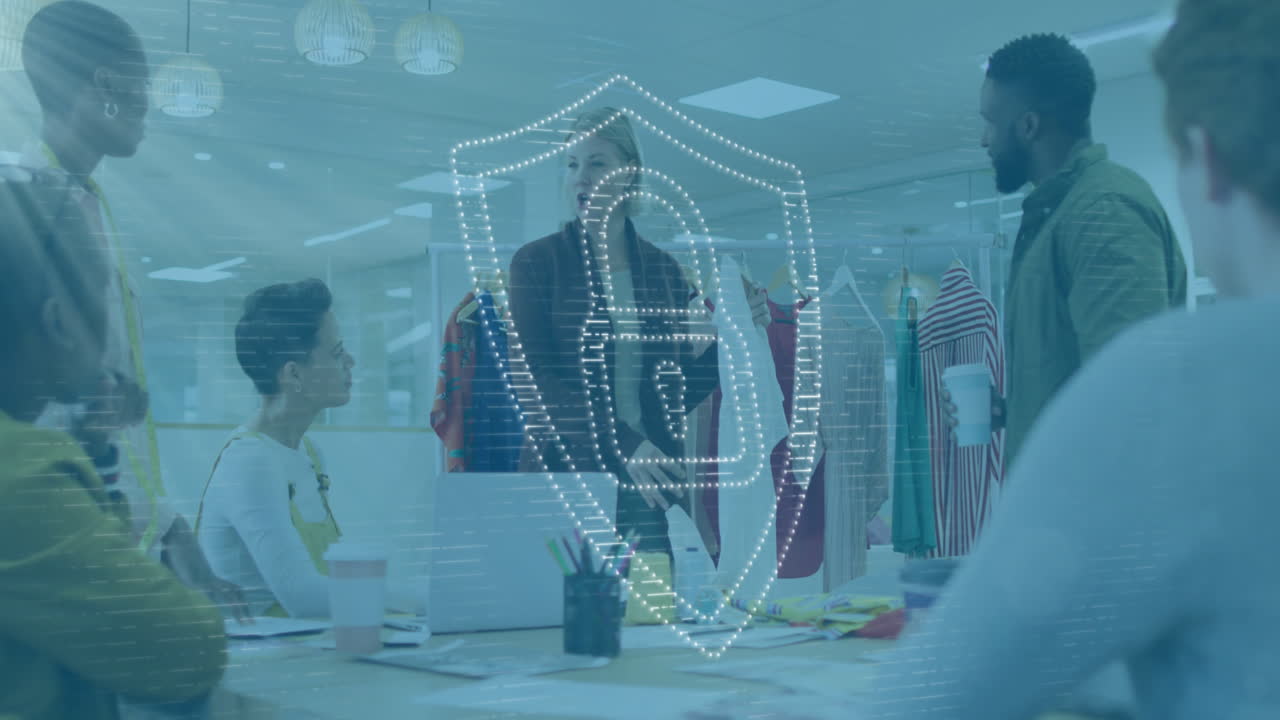 Animation of padlock in shield, diverse female holding cloth and explaining design to coworkers