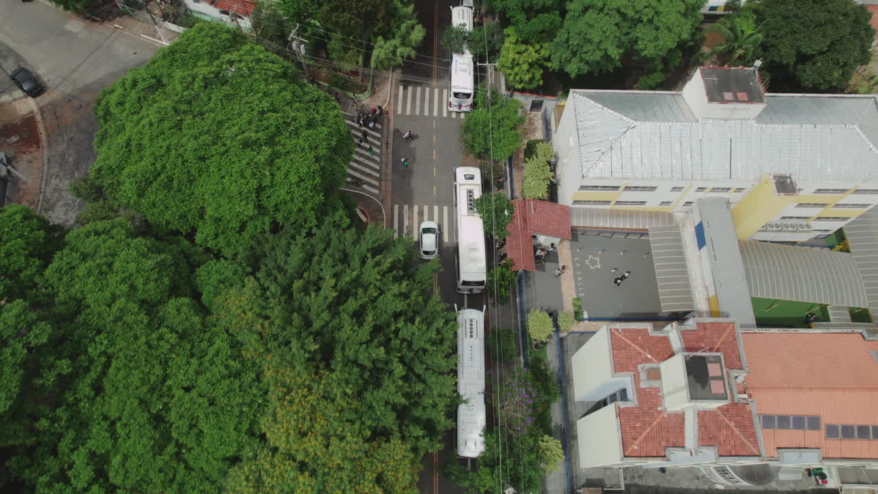 Aerial view of a city street with multiple buses and urban infrastructure