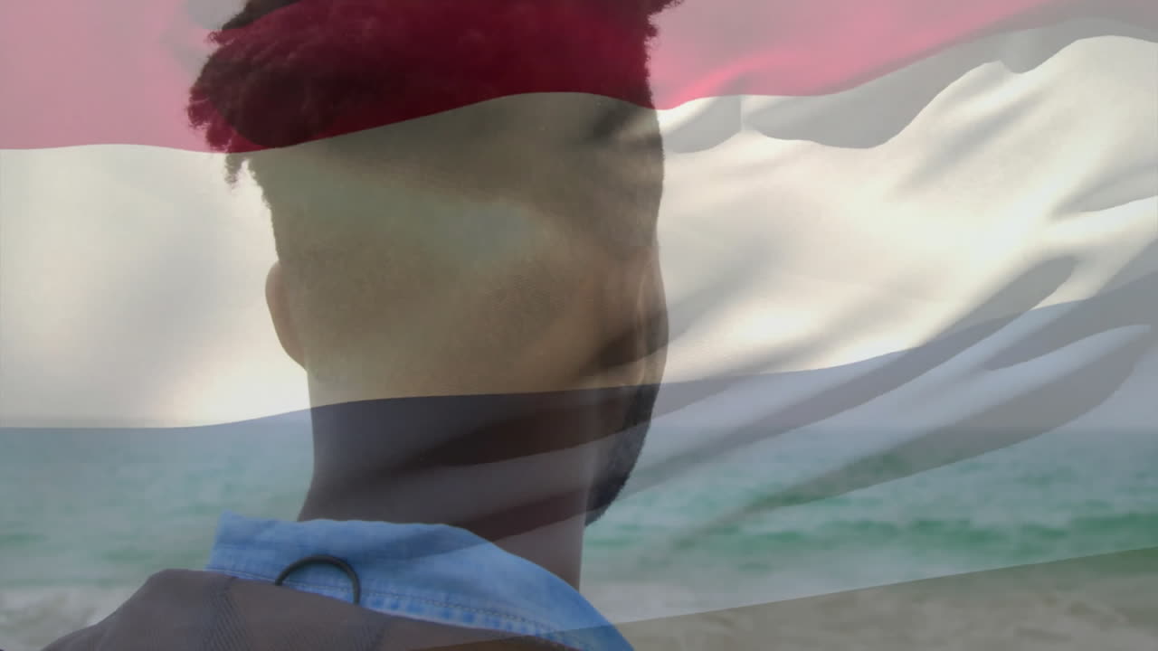 Looking at ocean with animation of Dutch flag colors, person with red hair