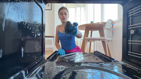 woman cleaning a dirty oven