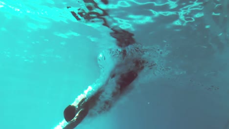 Underwater-view-of-athletic-man-diving-in-the-swimming-pool