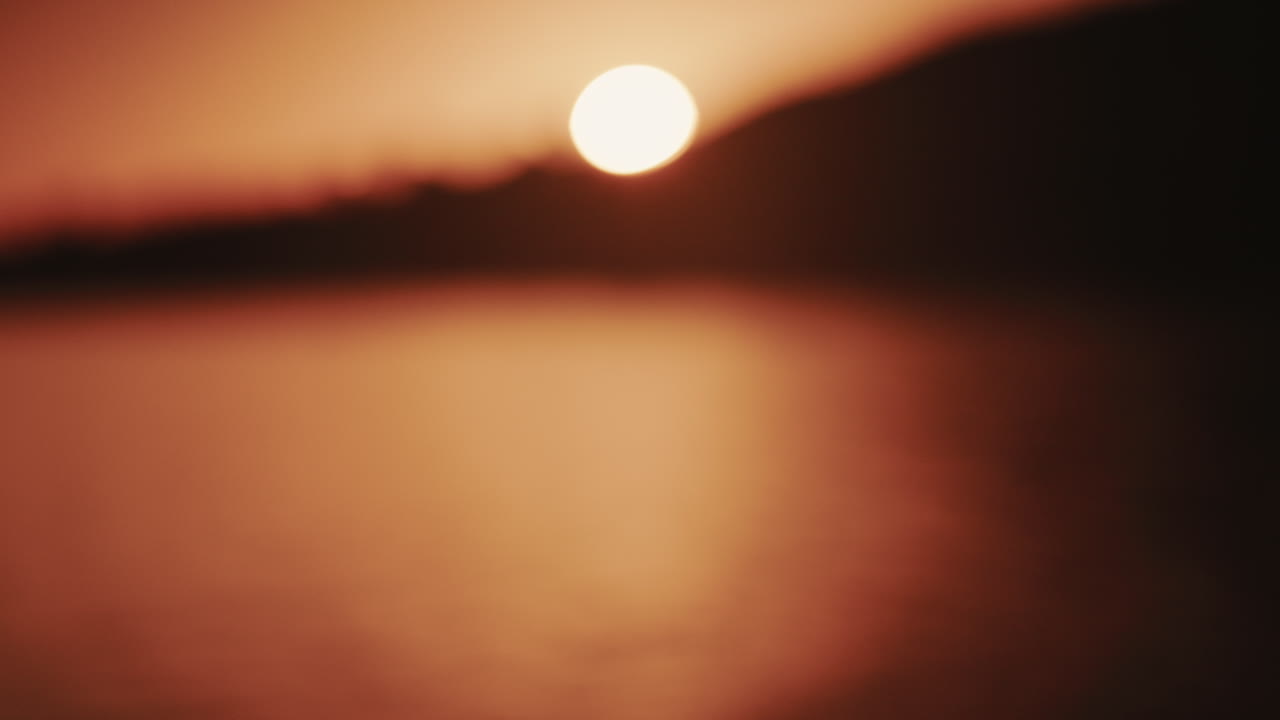 夕焼けが海面を照らし、水面に明るい反射を作り出しているワイドショット