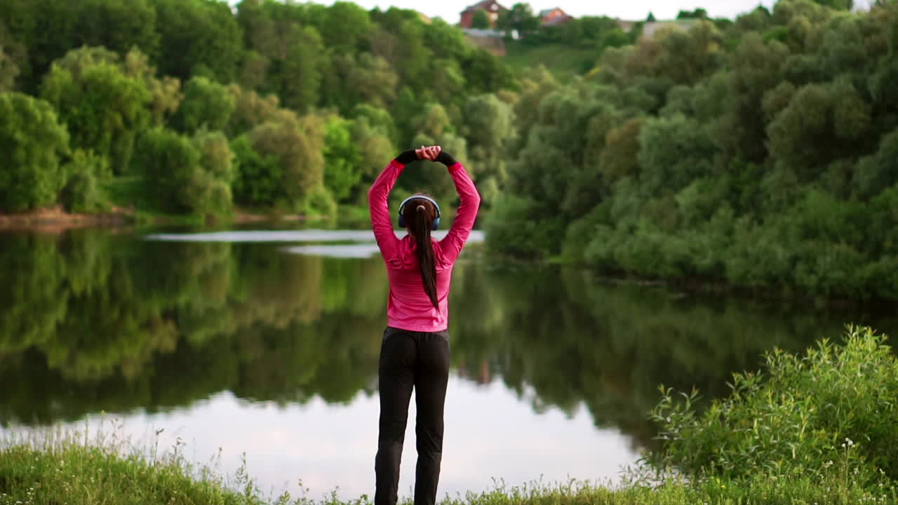 la chica se calienta temprano en la mañana antes del entrenamiento preparándose para una carrera en el sol