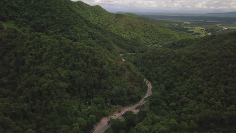 vista aérea de la carretera rural que pasa por la exuberante vegetación y el follaje del paisaje montañoso de la selva tropical
