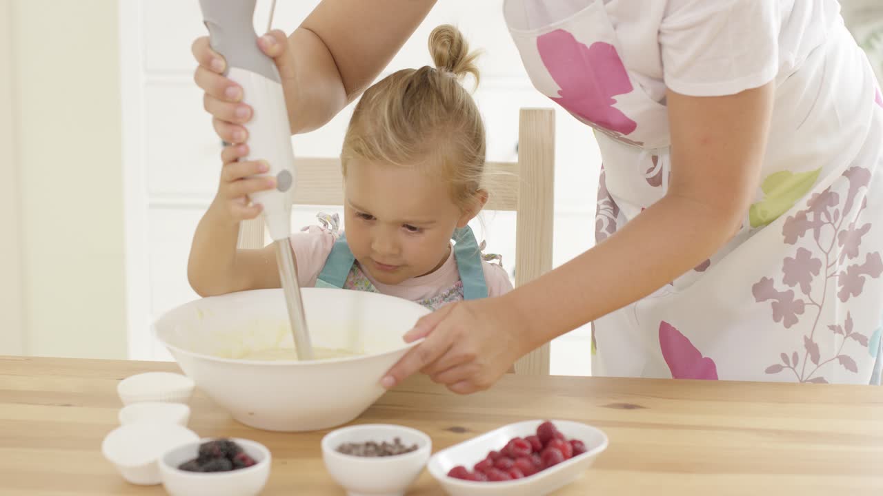 una chica rubia muy bonita aprendiendo a hornear.