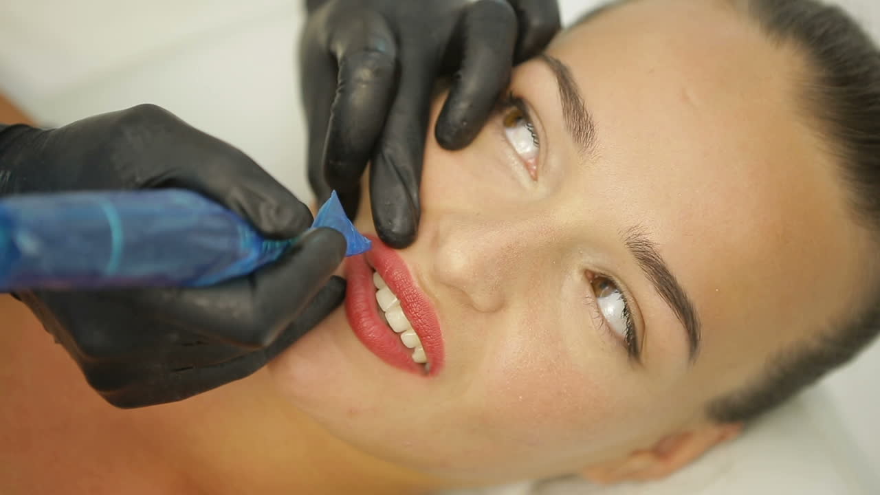 Permanent Makeup On Lips. Cosmetologist applying permanent make-up on lips