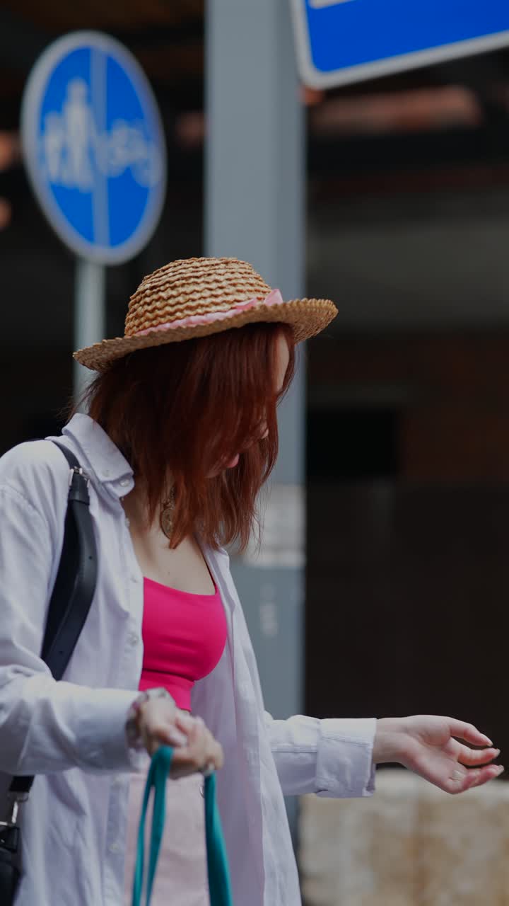 mujer con sombrero de paja en la calle de la ciudad